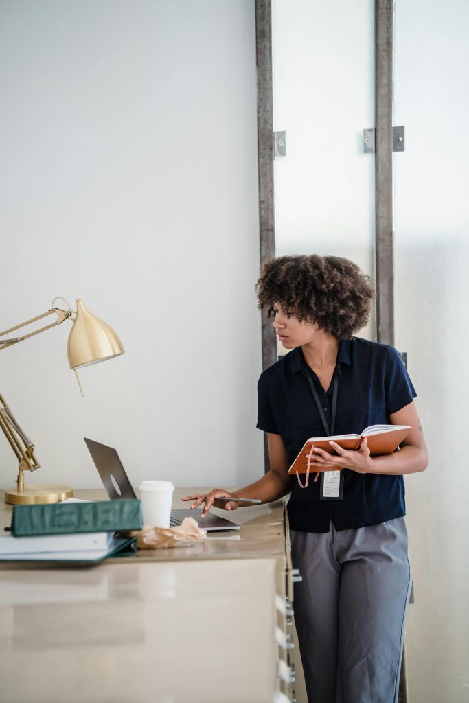 Photo of a woman standing next to he desk by pexels mizunokozuki 12911252 (1)